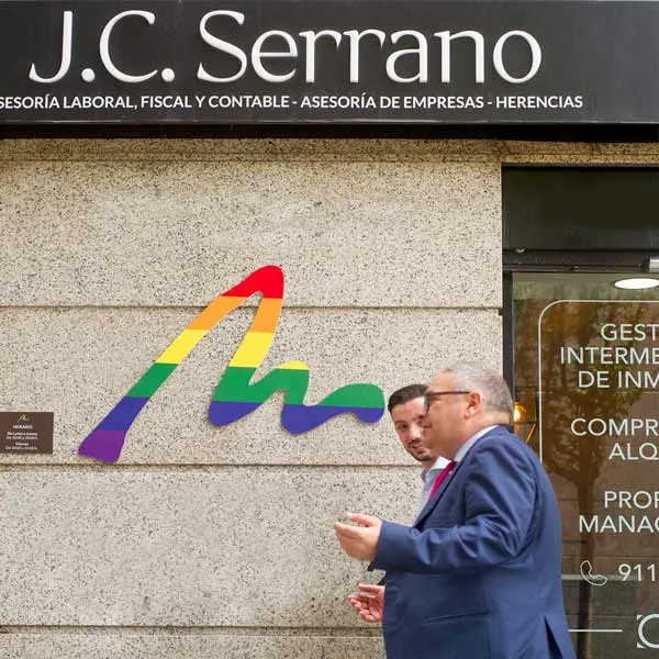 Fachada de JC Serrano AsesorÃƒÂ­a en Madrid, con dos personas conversando frente a la entrada.